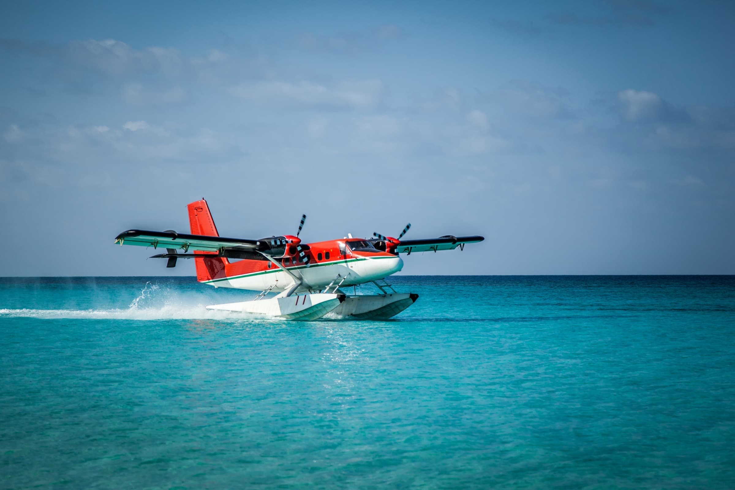 A seaplane touching down on clear turquoise water in the Florida Keys